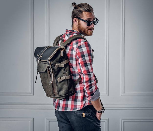 Free Photo stylish bearded hipster male showing leather rucksack on his back.