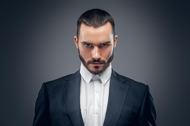 A stylish bearded male dressed in a business suit and a white shirt.