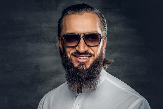 Free photo stylish bearded male in a white shirt and sunglasses isolated on grey background.