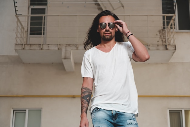 Stylish bearded man model posing with sunglasses