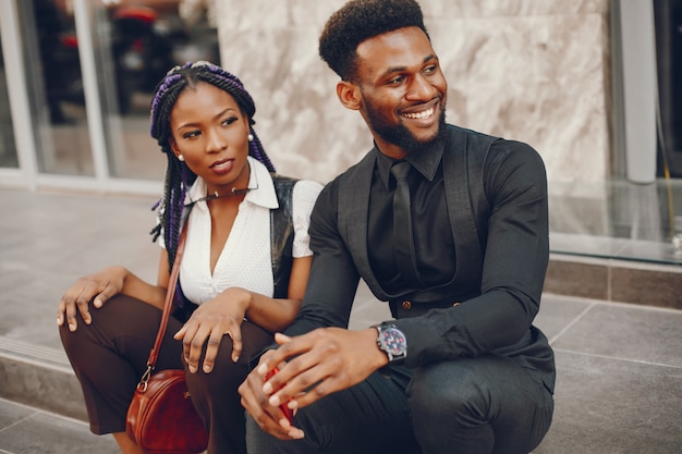 A stylish and beautiful dark-skinned couple in a city