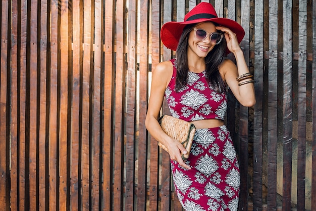 Stylish beautiful woman posing against wooden wall