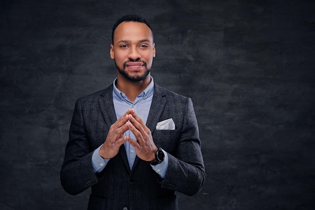 A stylish black American male dressed in a suit over grey background.