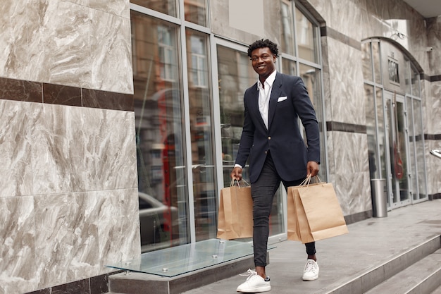 Stylish black man in a city with shopping bags