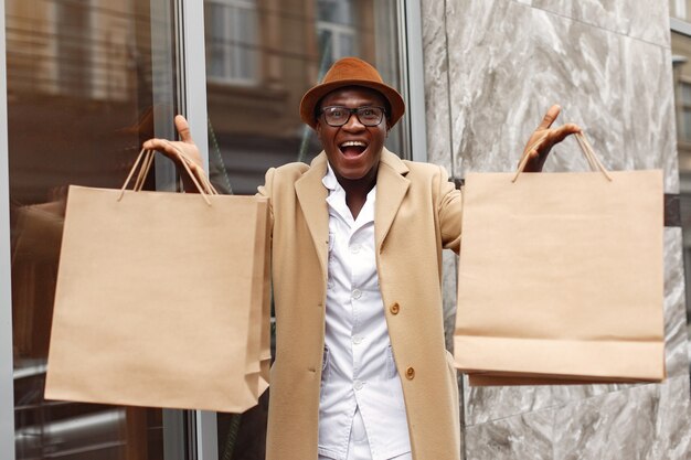 Stylish black man in a city with shopping bags