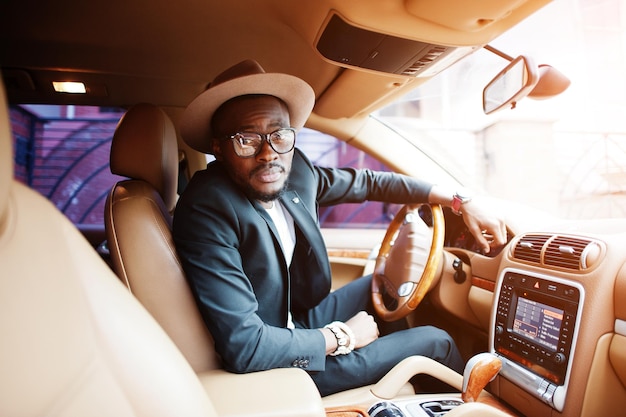 Stylish black man sitting behind the wheel of luxury car Rich african american businessman