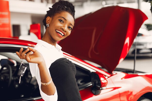 Stylish black woman in a car salon