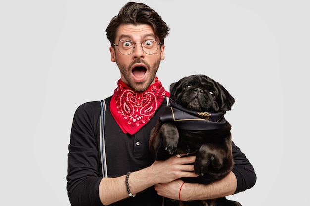 Stylish brunet man wearing red bandana holding dog