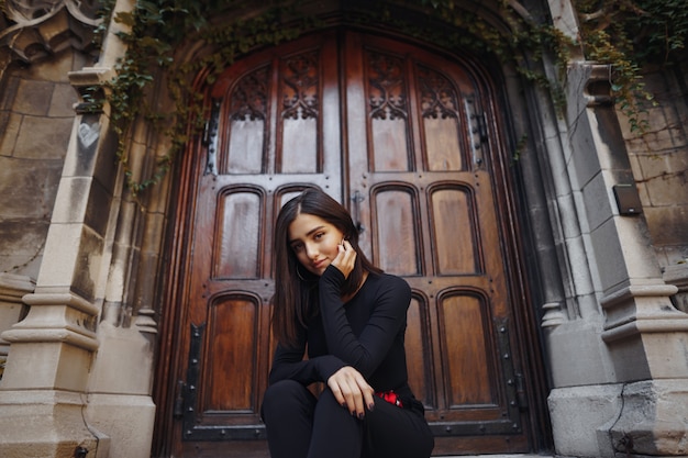 Free photo stylish brunette girl sitting on the stairs