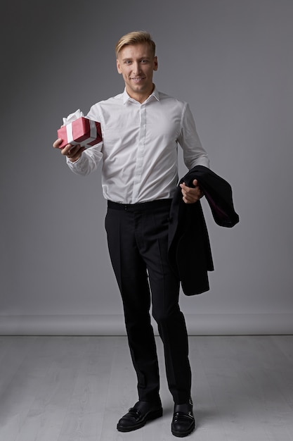 Free photo stylish businessman holding gift box