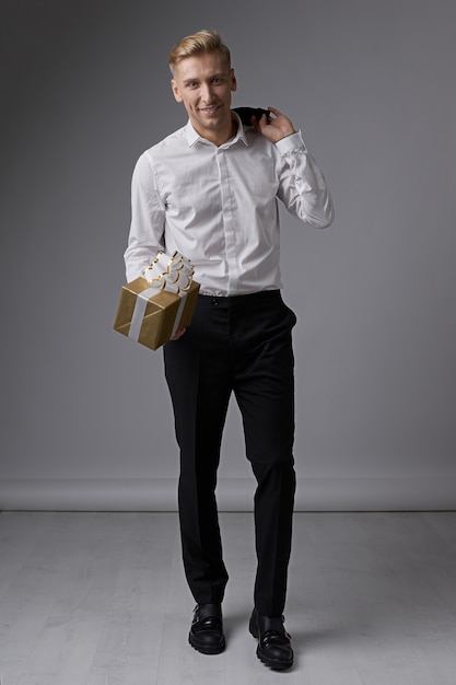 Free Photo stylish businessman holding gift box