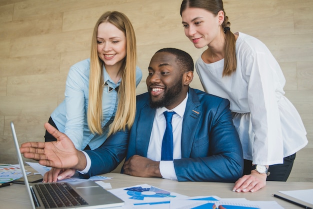 Free photo stylish businesspersons looking at laptop