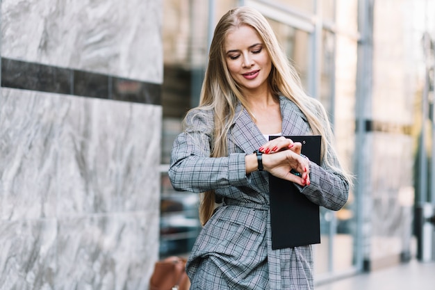 Stylish businesswoman looking at watch