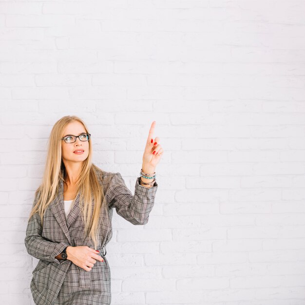 Stylish businesswoman pointing up