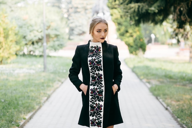 Free photo stylish businesswoman walking an posing