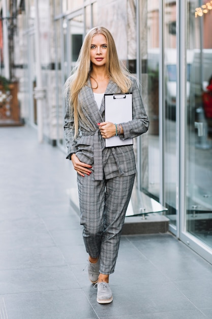 Free photo stylish businesswoman with clipboard in city