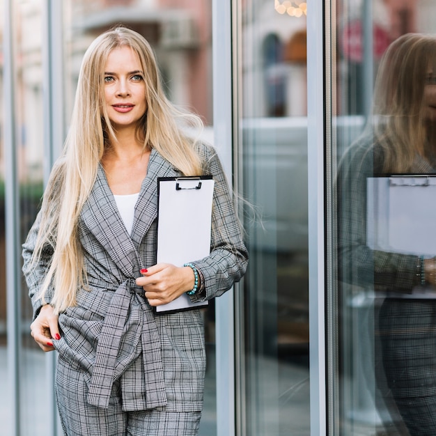 Free photo stylish businesswoman with clipboard in city