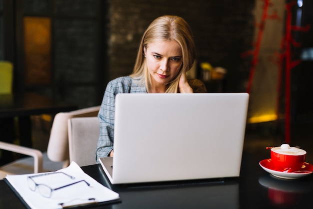 Stylish businesswoman with laptop in cosy coffee shop