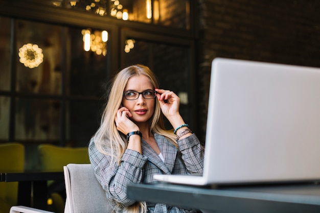 Stylish businesswoman with laptop in cosy coffee shop