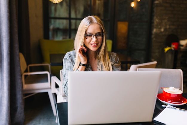 Stylish businesswoman with laptop in cosy coffee shop