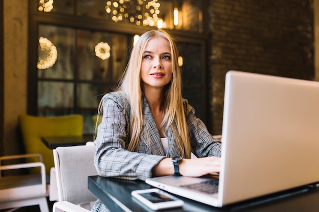 Stylish businesswoman with laptop at desk