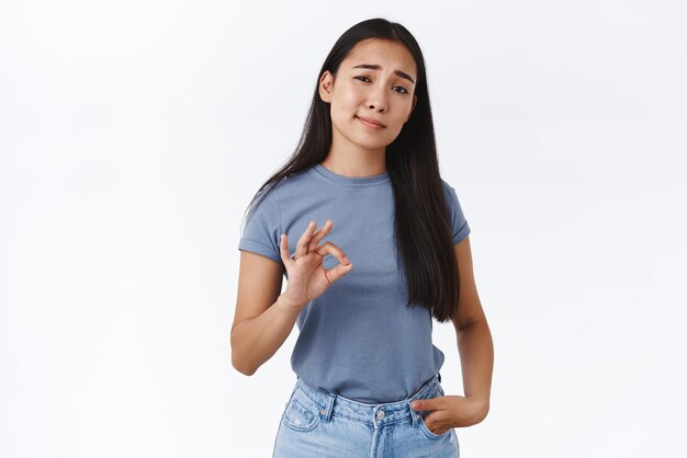 Stylish confident asian female entrepreneur rate something good give her opinion show okay ok sign and nod in approval agree idea sounds cool impressed with friend choice white background