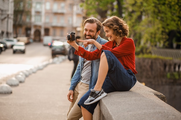 Free photo stylish couple in love sitting in street on romantic trip, taking photo