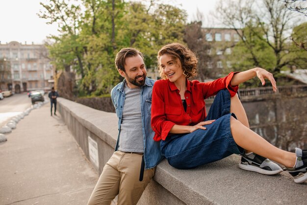 Stylish couple in love sitting in street on romantic trip