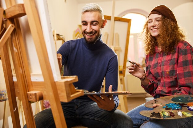 Stylish couple smiling draw a painting