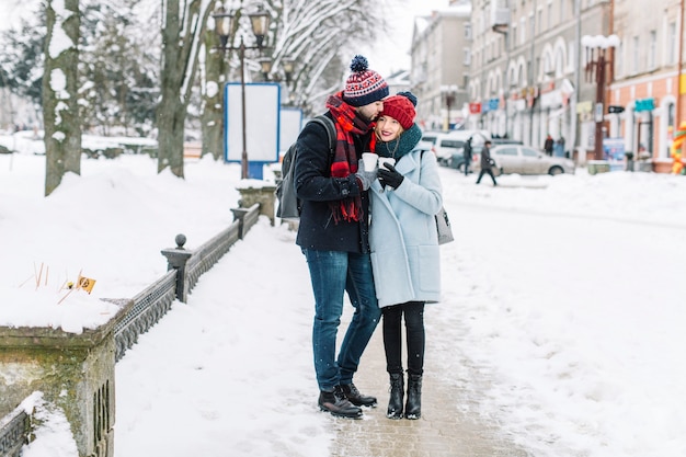 Stylish couple with coffee in winter city