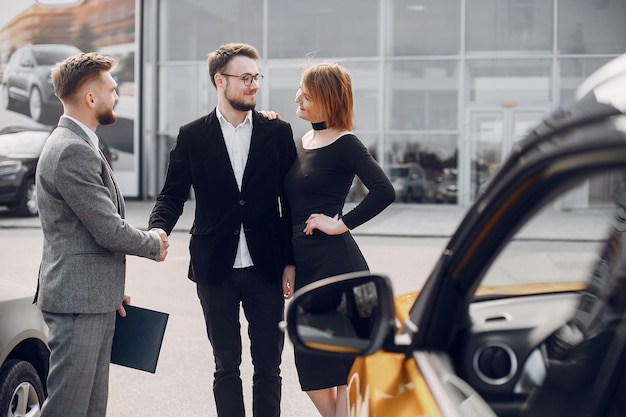 Stylish and elegant couple in a car salon