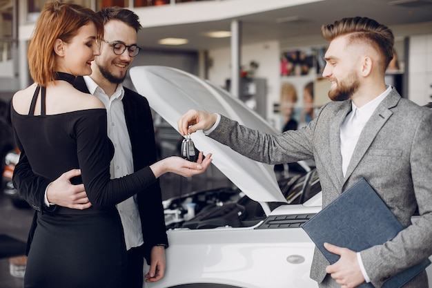 Stylish and elegant couple in a car salon