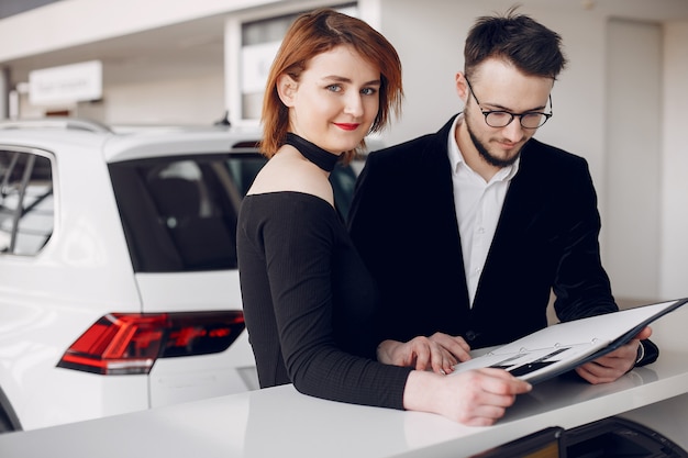 Free photo stylish and elegant couple in a car salon