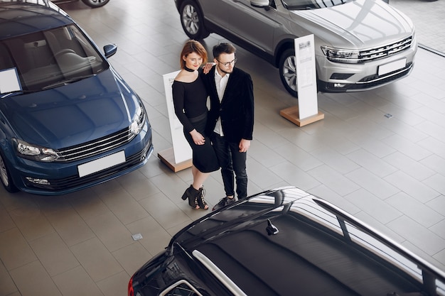 Stylish and elegant couple in a car salon