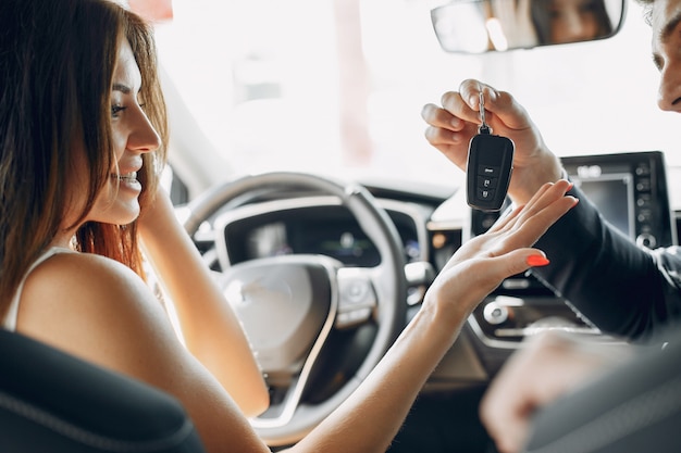 Stylish and elegant couple in a car salon