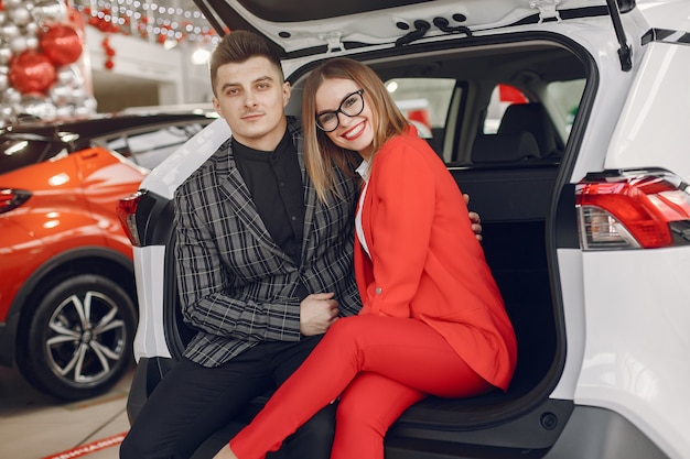 Stylish and elegant couple in a car salon