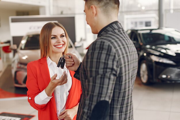 Stylish and elegant couple in a car salon