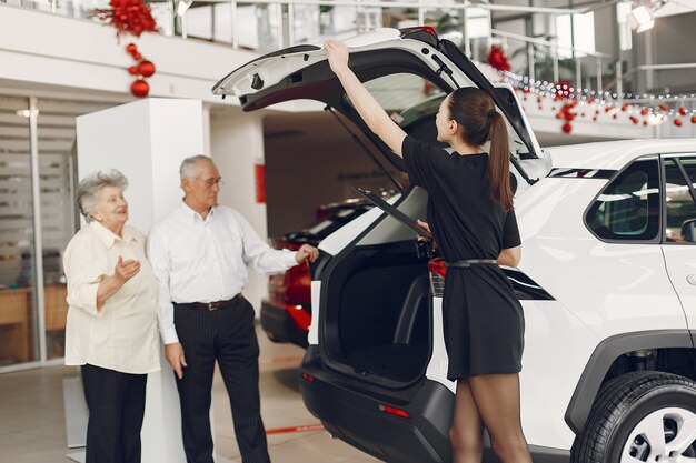 Stylish and elegant old couple in a car salon