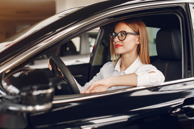 Stylish and elegant woman in a car salon