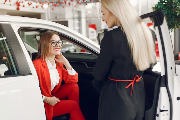 Stylish and elegant women in a car salon