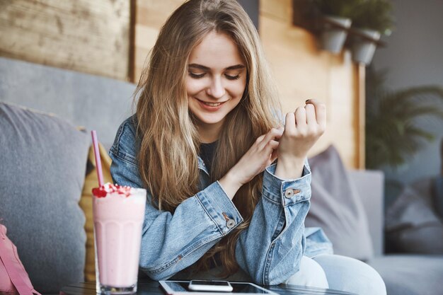 Stylish european girlfriend with fair hair in denim jacket sitt