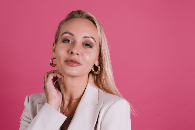 Free Photo stylish european woman in elegant beige blazer and golden jewelry, pretty makeup and big lips, posing