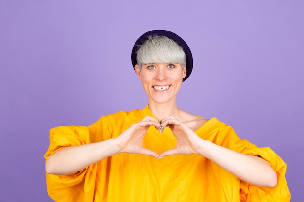 Free photo stylish european woman on purple wall