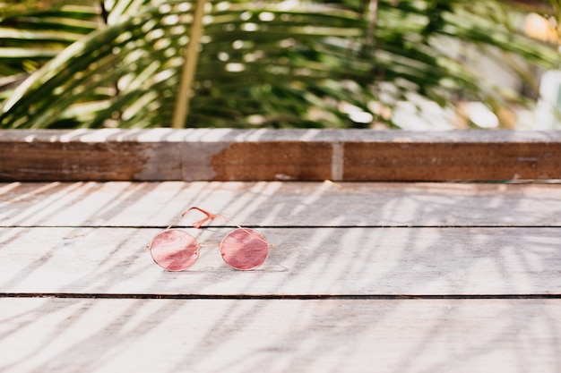 Stylish female glasses lying on wooden table.