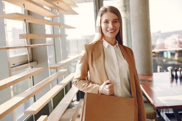 Free photo stylish girl standing in a cafe with shopping bags