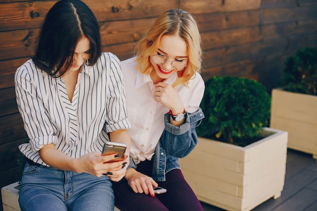 stylish girls sitting in a city