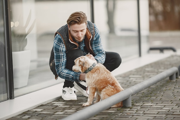 Free Photo stylish guy playing with a dog. man in autumn city.