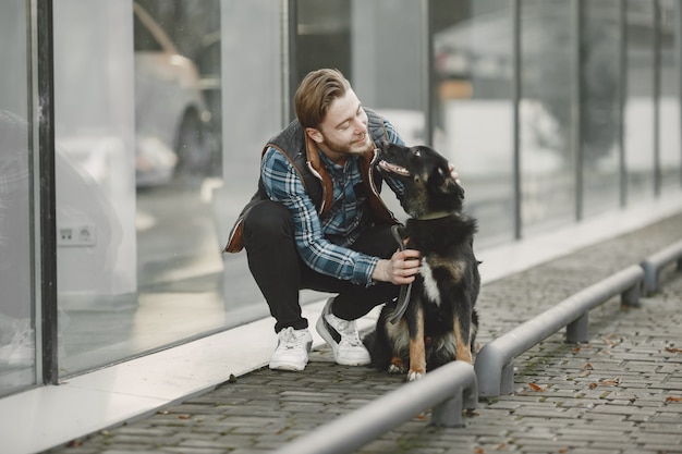 Free Photo stylish guy playing with a dog. man in autumn city.