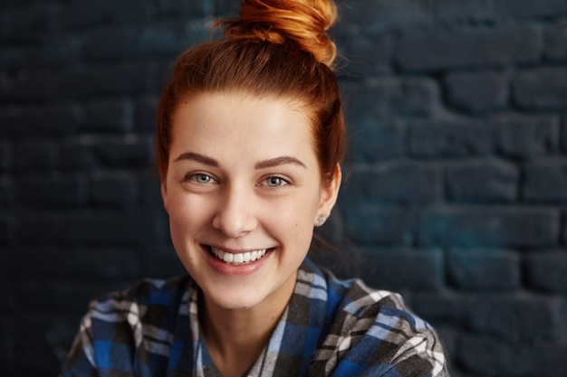 Free photo stylish happy young european woman with ginger hair and charming smile looking