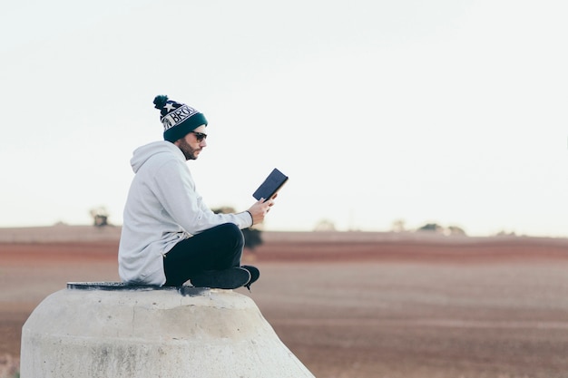 Free photo stylish hipster man with tablet outside